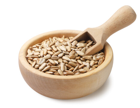 Sunflower seed kernels in a wooden bowl with a scoop on a white. Isolated