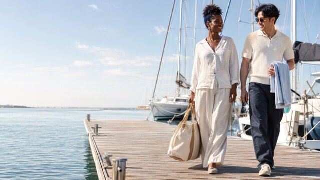 Couple walking on marina dock with sailboats, embodying sailorcore yachting lifestyle