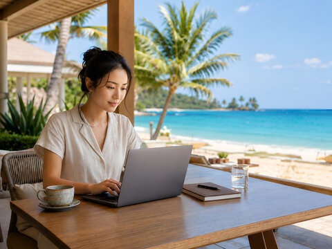 Asian Woman Working Remotely on Laptop at Tropical Beach Resort, Workation Lifestyle