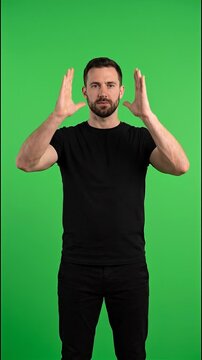 Vertical video of man framing invisible box against green screen