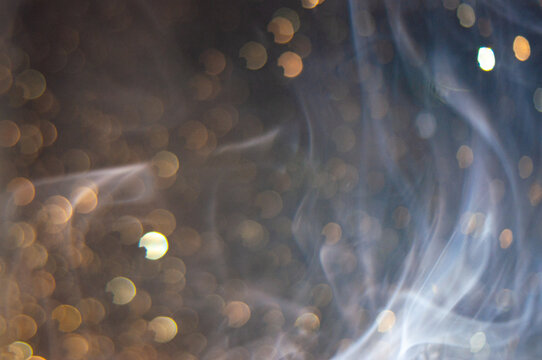 Smoky scene with glowing specks in a dark background during nighttime