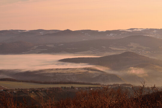 Layered mountain ridges emerging from a dense morning cloud inversion in Czechia