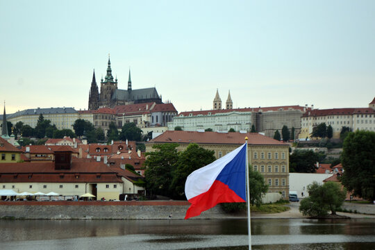 Czech republic flag flying over the vltava river with prague castle skyline for travel background and landmark banner