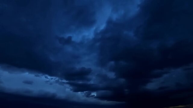 Time lapse clouds forming and rolling across stormy sky over distant horizon at dusk approaching thunderstorm and heavy rain
