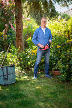 Full length of a senior mand gardening in a back yard