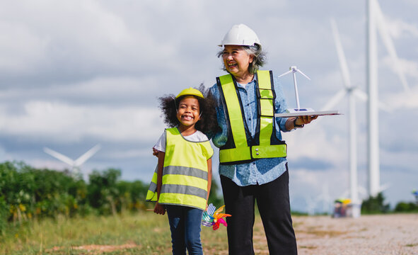 Happy children explore wind energy with a smiling adult