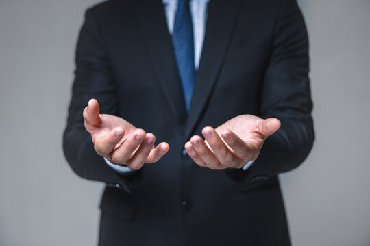 Businessman stands with hands open, palms up