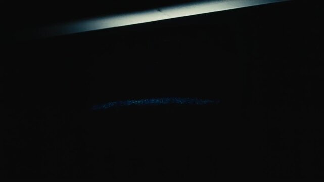 Static shot of flickering television static gradually shrinking and fading to near darkness on vintage crt set in dark interior living room with minimal ambient light