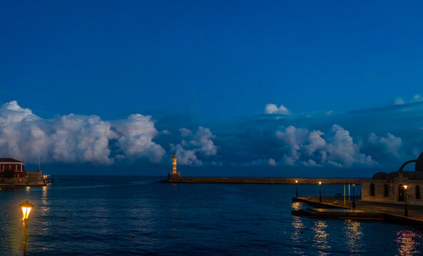 Chania Lighthouse set against a deep blue dawn sky in the historic Old Venetian Harbour of Chania, Crete, Greece