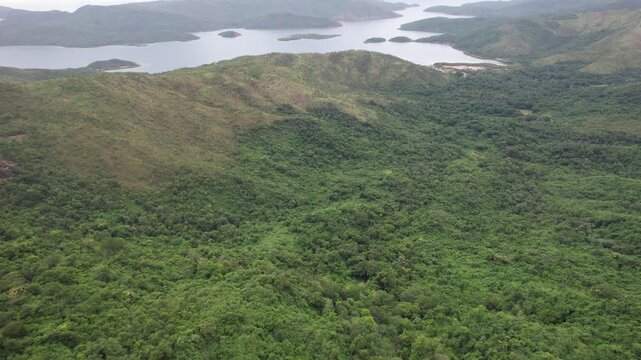 Aerial tilt-up reveal of stunning lush tropical coastal landscape of Mochima National Park, Venezuela, under soft overcast sunlight.