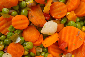 A detailed close up shot of a colorful vegetable mix featuring sliced crinkle cut carrots green...