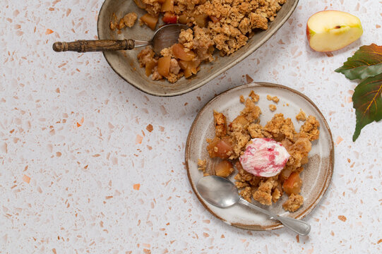Portion of apple oat crumble with ice cream in dish
