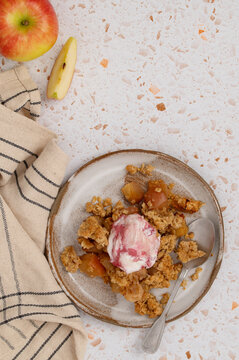 Portion of apple oat crumble with ice cream in dish