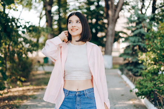 Teenage girl smiling and posing outdoors in a summer park