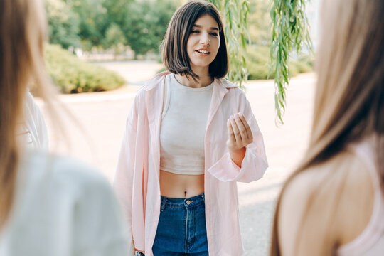 Teenage girls talking and sharing ideas with friends outdoors