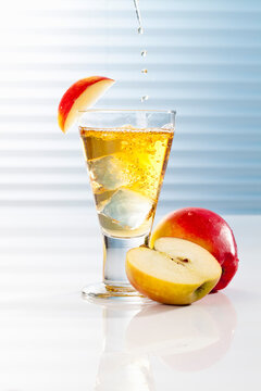 Glass with apple juice and halved apples