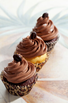 Three with mocha beans decorated cup cakes in paper cups