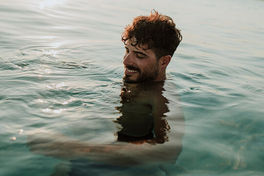 A smiling male enjoys the Mediterranean sea during summer vacation