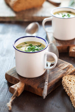 Enamel cup of pea soup with chives