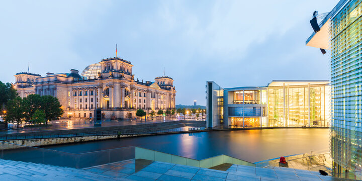 Germany, Berlin, view to lighted Reichstag and Paul-Loebe-Building with Spree River in the foreground