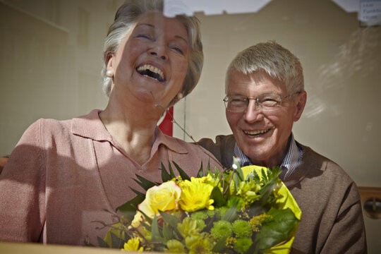 A man and woman hold a flower bouquet at a retirement home in Cologne