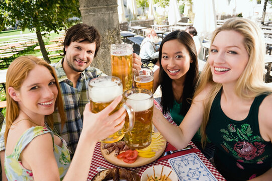 Germany, Bavaria, Upper Bavaria, Young people in beer garden, smiling