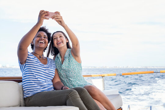 Two happy young women on a boat trip taking a selfie