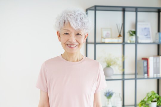 リビングに立って微笑む日本人シニア女性のポートレート