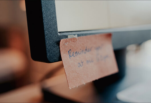 Sticky note reminder on a computer monitor