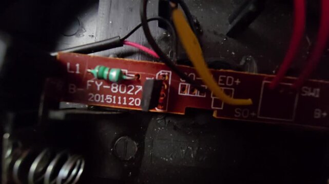  Close-up macro shot of an internal electronic circuit board (PCB) and wiring components from a mini solar-powered garden light.