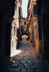 Fototapeta premium Narrow old street with cobblestone and historic buildings in a Mediterranean village