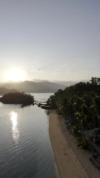 Aerial drone view of Coconut trees and shoreline facing the rising sun at Pangulatan beach