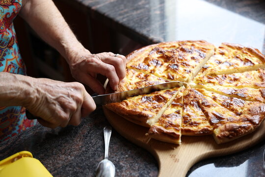 Grand-m&egrave;re d&eacute;coupant une tarte &agrave; la cr&egrave;me jurassienne faite maison