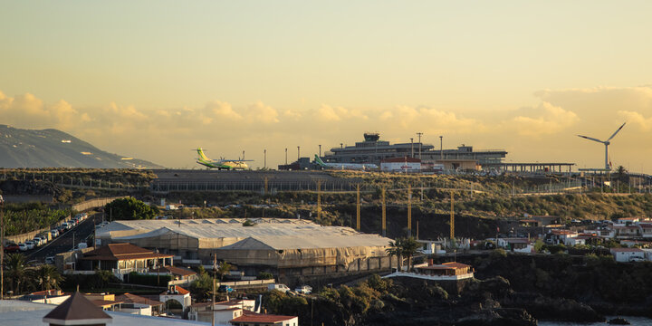 La Palma, Islas Canarias, Espa&ntilde;a. 9 de Mayo 2026. Vista del Aeropuerto de La Palma con aviones de Binter en la pista, la torre de control y un aerogenerador bajo la c&aacute;lida luz dorada del amanecer.