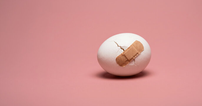 Cracked Egg Repaired with Bandage, Fragile Recovery and Healing After Damage Concept
