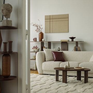 Modern minimalist living room interior with cream sofa, wooden coffee table, sculpture art, and abstract wall decor in a warm cozy home design