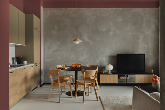 Open-plan kitchen and dining area with green cabinets, wooden finishes and orange accent walls.