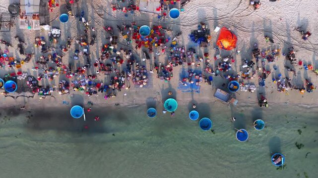 Aerial view of morning seafood market on Doc Let beach, Khanh Hoa province with local vendors and baskets in Vietnam