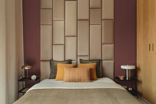 Modern luxury bedroom interior design with velvet upholstered headboard, warm earth tones, wooden wardrobe, stylish pillows, and nightstands