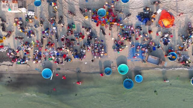 Aerial view of morning seafood market on Doc Let beach, Khanh Hoa province with local vendors and baskets in Vietnam