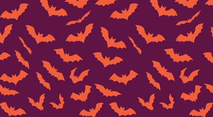 Fototapeta premium Seamless Halloween bat vector pattern with orange flying silhouettes on a deep purple background, ideal for spooky wallpapers, textiles, wrapping paper, party decor and seasonal designs.