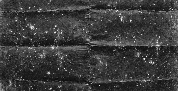 Aged Folded Black Paper Texture with White Paint Splatters - Distressed Grungy Cardboard Background with Creases
