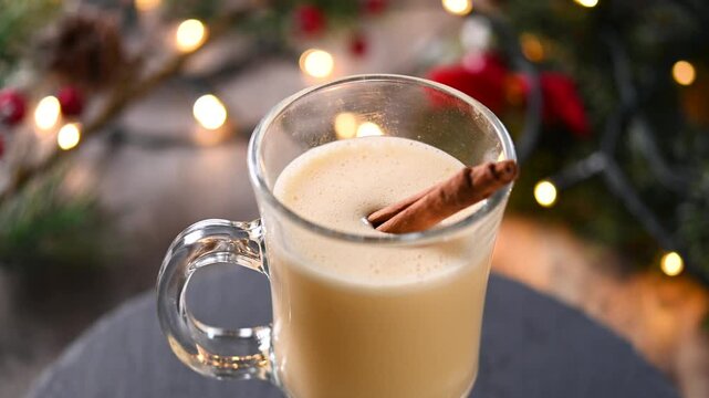 Traditional Christmas eggnog drink rotating in glass