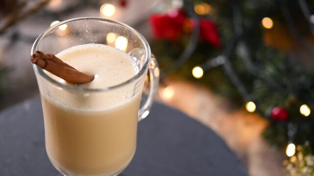Traditional Christmas eggnog drink rotating in glass