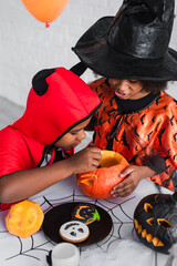 Fototapeta premium Little siblings celebrate Halloween with joy and creativity in colorful costumes