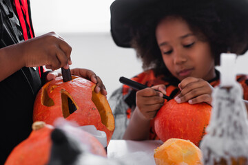 Fototapeta premium Halloween fun with kids carving pumpkins in a cozy autumn setting