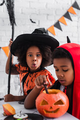 Fototapeta premium Celebrating the joy of Halloween with adorable siblings in vibrant costumes