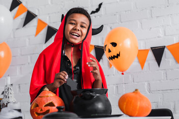Fototapeta premium Little boy enjoys Halloween fun in vibrant costume with festive decorations