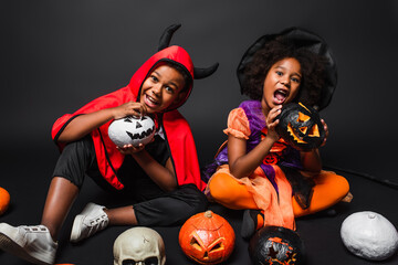 Fototapeta premium Little siblings in vibrant Halloween costumes share joy during a spooky celebration