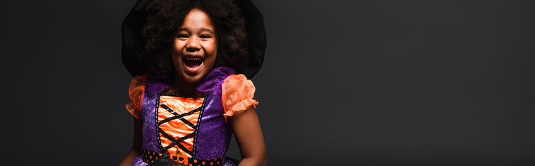 Fototapeta premium Cute little girl dressed in a vibrant Halloween costume enjoying the spooky season